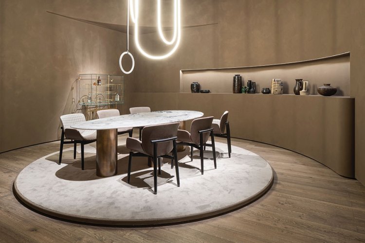 moderner Tisch und Stühle auf beigem Teppich gruppiert in einem hellbraunen Raum, der von gebogenen Neonröhren beleuchtet ist