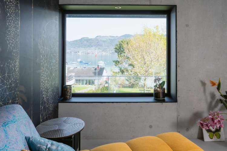 Raum mit Betonwand mit Fenster mit tiefem Fenstersims und Aussicht auf See