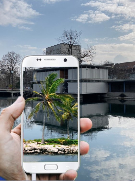 Bild der Badi Letten, davor ein weisses Handy, auf dem eine Insel mit Palme in der Limmat sichtbar ist