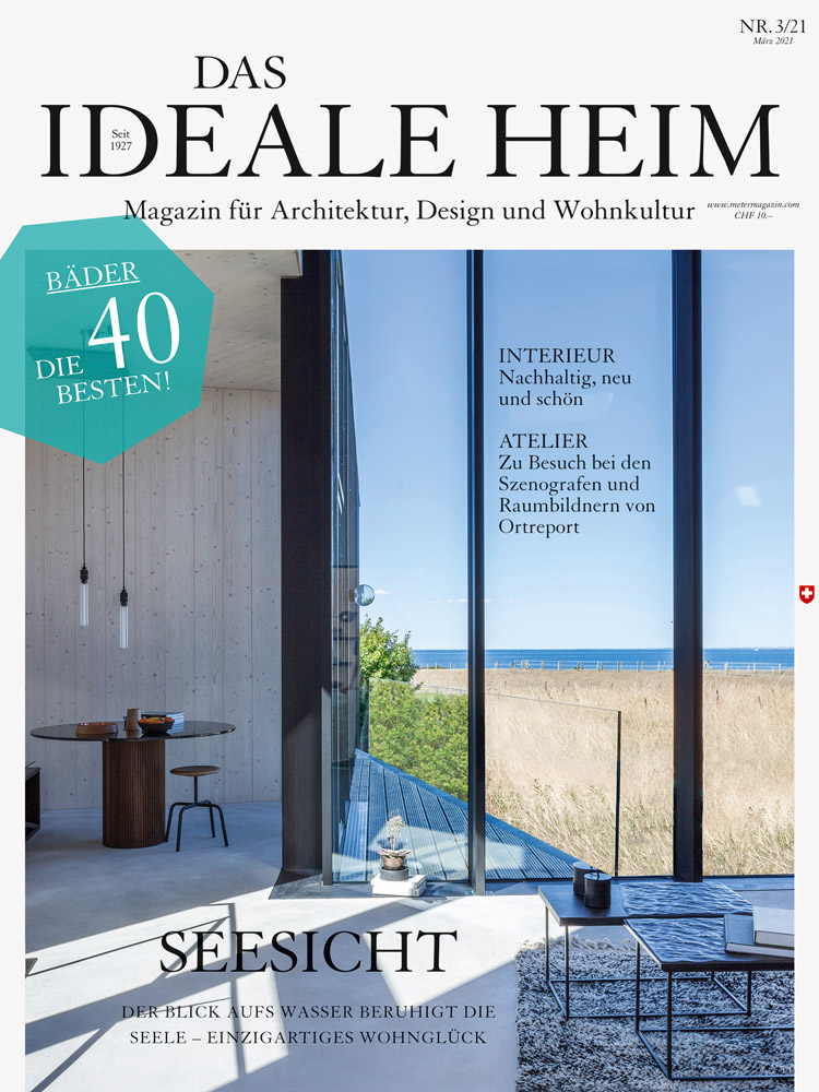 Titelblatt von der März-Ausgabe von Das Ideale Hei auf dem Bild ist ein heller Wohnraum zu sehen mit Blick durch eine grosse Fensterfront in die freie Natur.