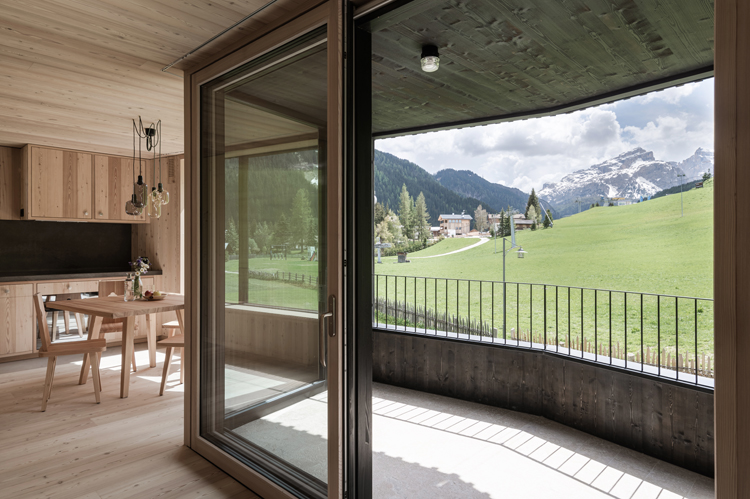 Blick aus einem Panoramafenster in die Dolomiten, Wohnung mit Lärchenholz verkleidet.