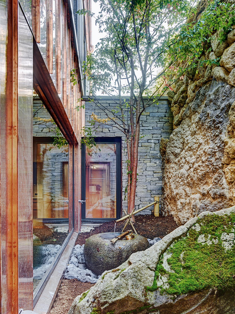Seitenansicht von Haus mit japanischem Steingarten.
