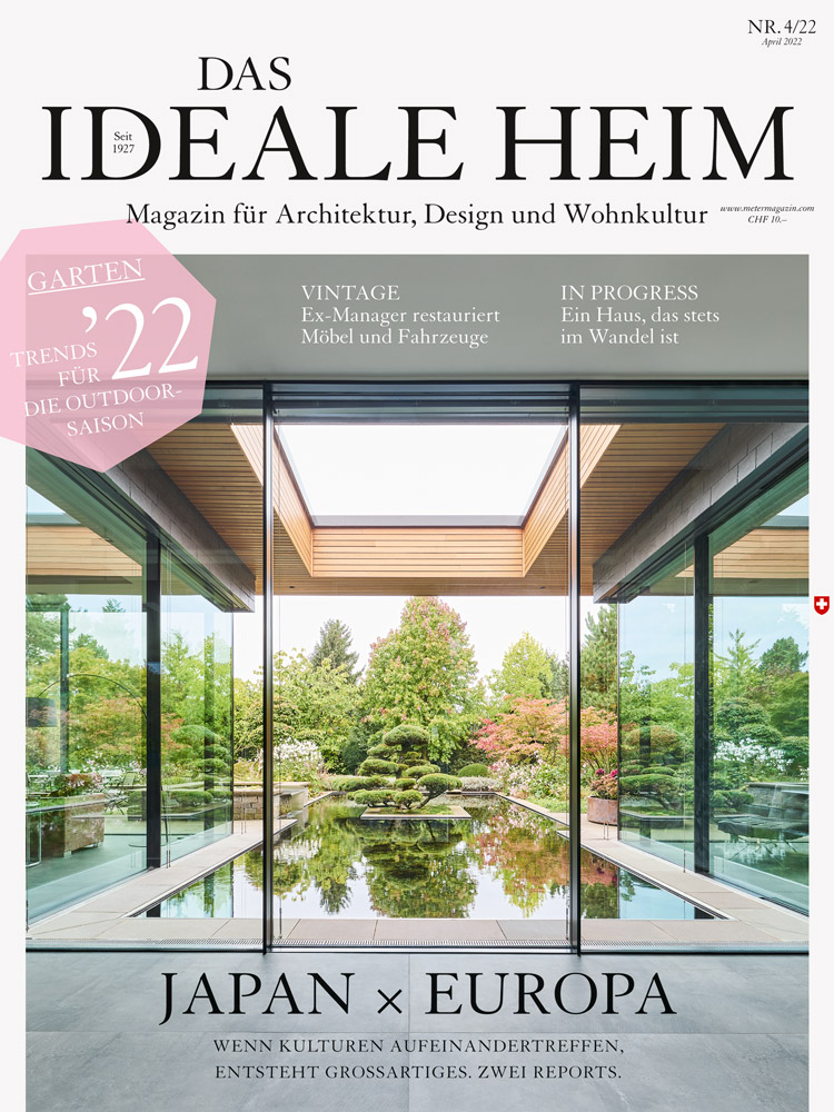 Cover des Magazins Das Ideale Heim Ausgabe April 2022 mit Innenansicht von einem Haus im Japanstil mit grossen Fensterfronten und Blick auf einen Teich mit einem Japanbaum.