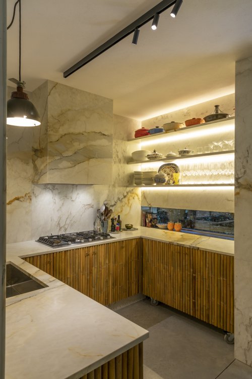 Blick in die Küche mit weisser Abdeckung und Bambusrohr-Schränken.