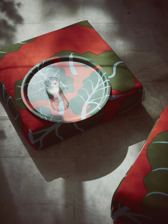 Sitzkissen mit Motiv von grünen Blättern und einem runden Tablett im gleichen Design.
