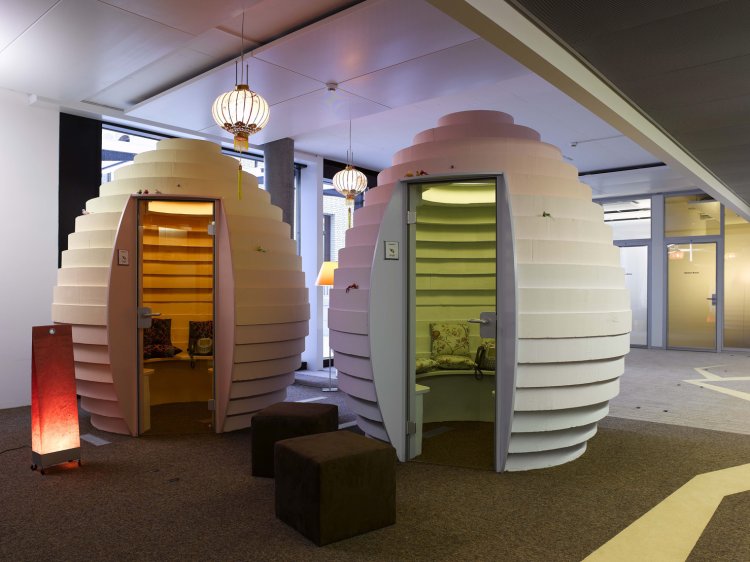 Eiförmige Kubusse aus Holz, die als Meetingraum genutzt werden können.