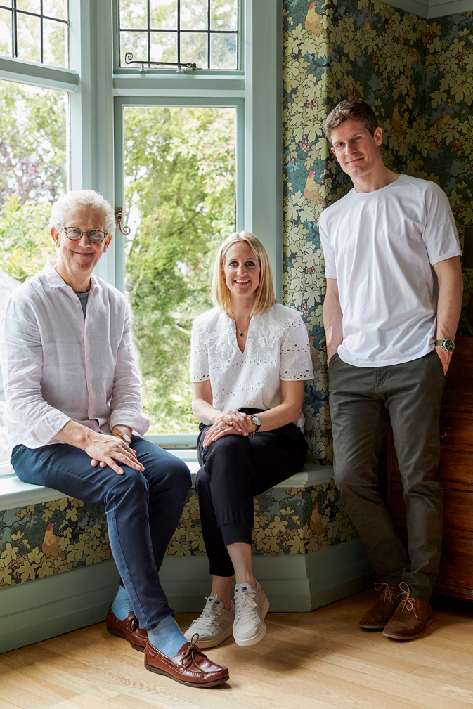 Porträtbild von David, Ruth & Ben Mottershead sitzend und der letzte stehend vor einem grossen Fenster mit Blick ins Grüne.