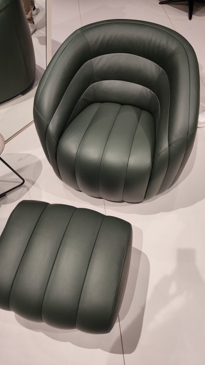Ein schwarzer Sessel mit Fussablage.
