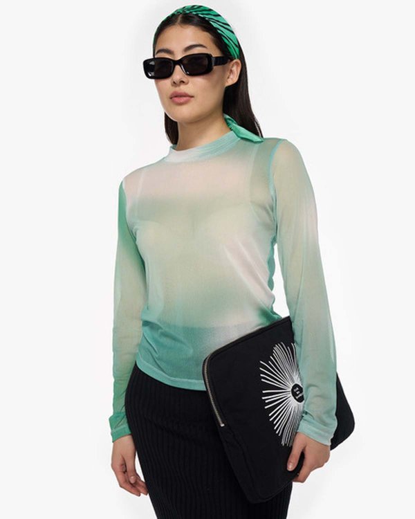 Model mit türkis-grünem Langarmshirt und schwarzer Sonnenbrille.