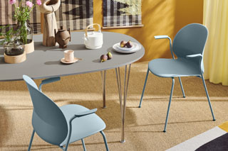 Zwei hellblaue Stühle stehen an einem Tisch.