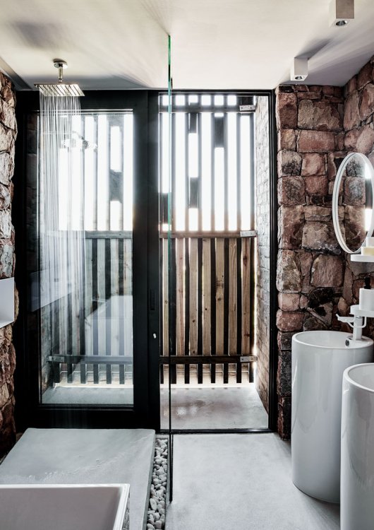 Das Fenster des Badezimmers ist mit Holzlatten verkleidet und lässt das Licht im Bad in einer besonderen Stimmung wirken.