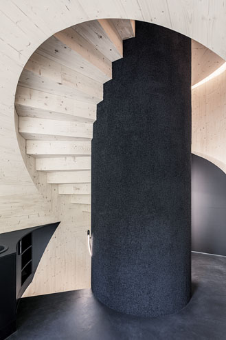 Ein helles Treppenhaus mit kontraststarken schwarz in der Mitte als Säule.