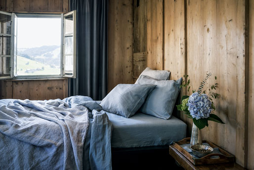 Ein Bett steht in einem mit Holz verkleideten Zimmer.