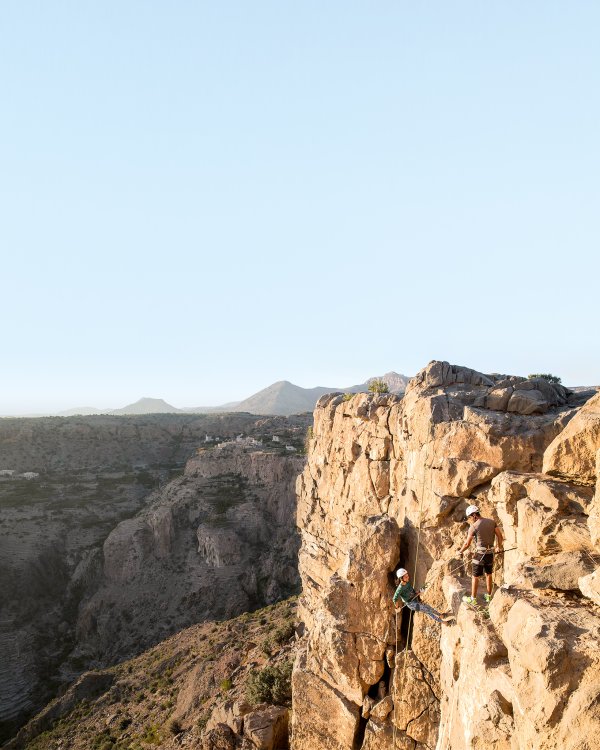 Hotelgäste die beim Klettern auf einem Felsen ihr Freizeit Angebot geniessen.