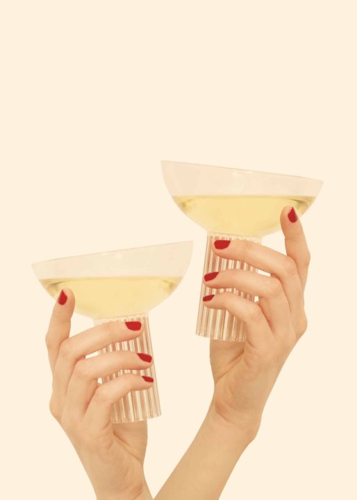 Zwei Hände mit zwei gefüllten Gläsern aus dem Set «Calici» von Designerin Agustina Bottoni.