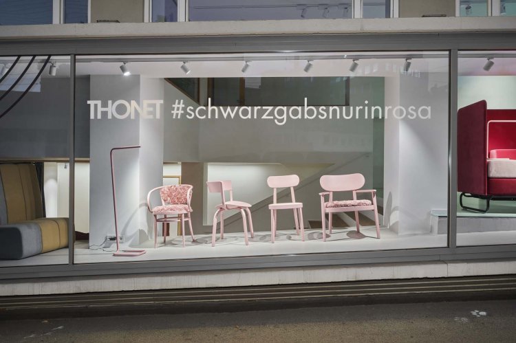 Das Schaufenster des Studio HANS in Stuttgart von Aussen bei Nacht fotografiert, in dem vier unterschiedliche Thonet-Stühle in hellrosa ausgestellt sind.