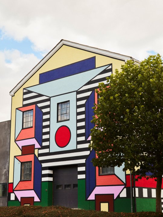Die von der Künstlerin Camille Walala gestaltete bunte Fassade der Montana-Fabrik in knalligen Farben und Mustern im Memphis-Stil.